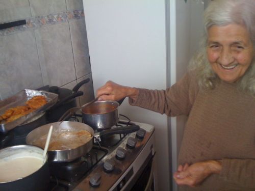 Dona Deza cozinha sorrindo